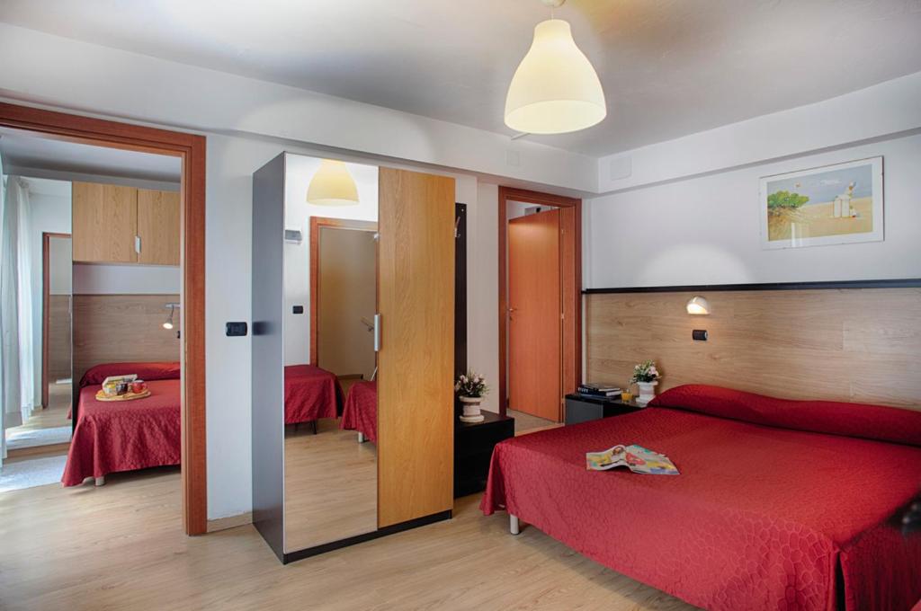 une chambre d'hôtel avec deux lits et un miroir dans l'établissement Club Hotel Angelini, à Bellaria-Igea Marina 22 autres photos