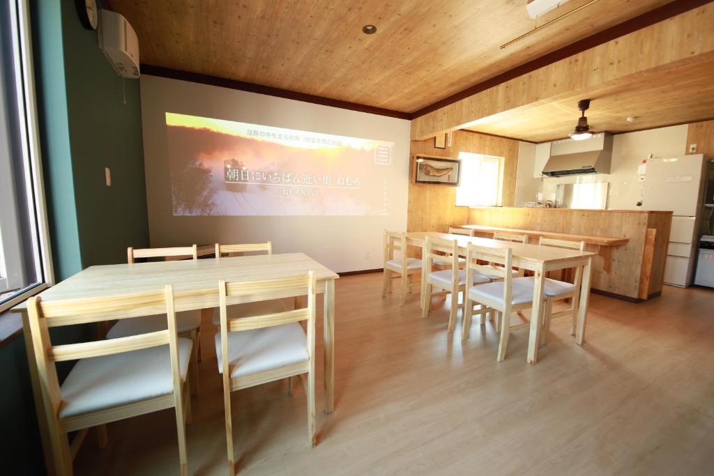 une salle à manger avec tables et chaises et un paravent dans l'établissement Guest House Nemuroman, à Nemuro 20 autres photos