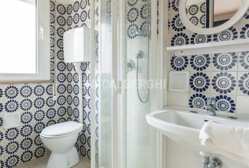 une salle de bain avec toilettes, douche et lavabo dans l'établissement Hotel Paradiso, à Rimini