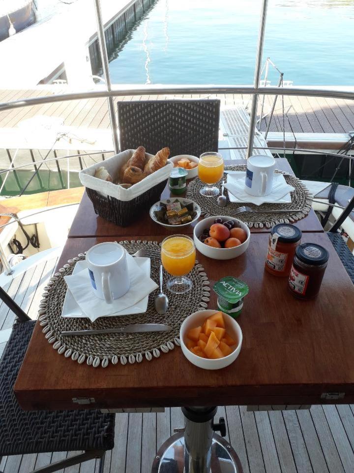 - une table avec petit-déjeuner composé de nourriture et de jus d'orange dans l'établissement Ocean Yacht Trawler - Le Caloa, à Porto-Vecchio
