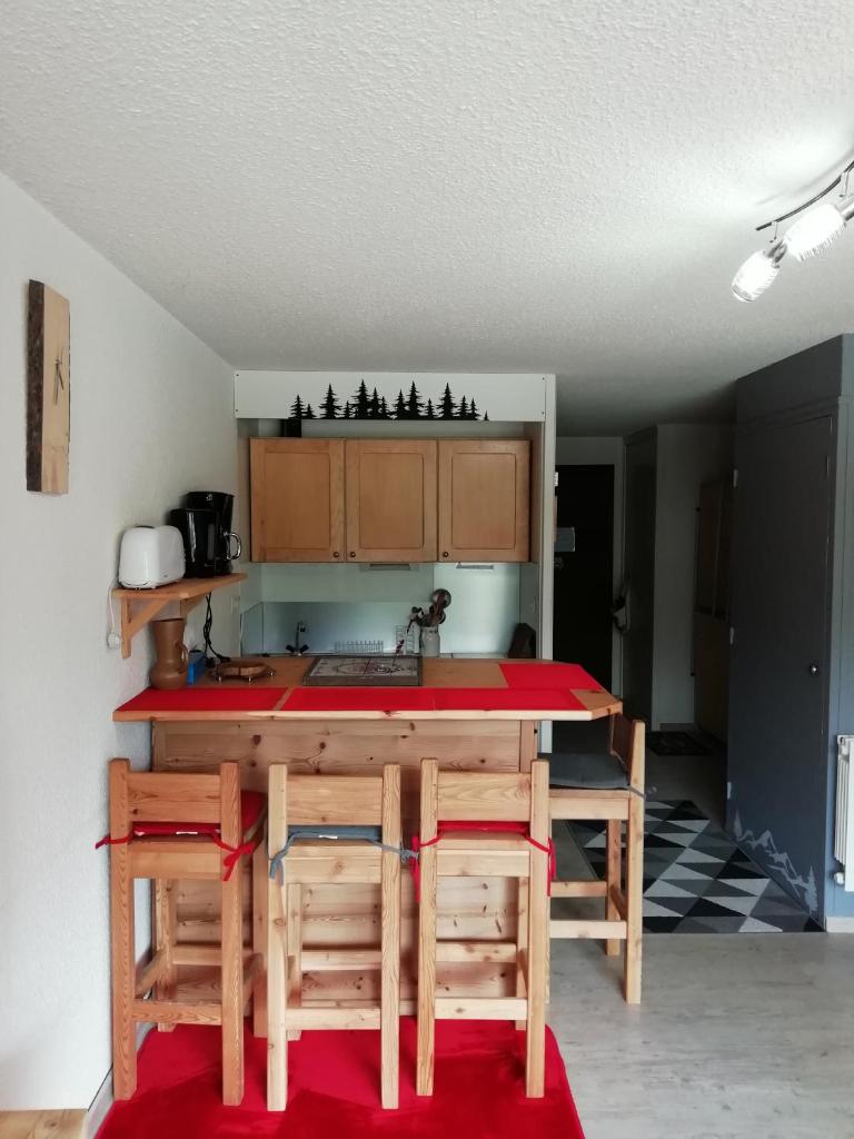- une cuisine avec une table, des chaises et un comptoir dans l'établissement Le Galibier, à La Salle Les Alpes