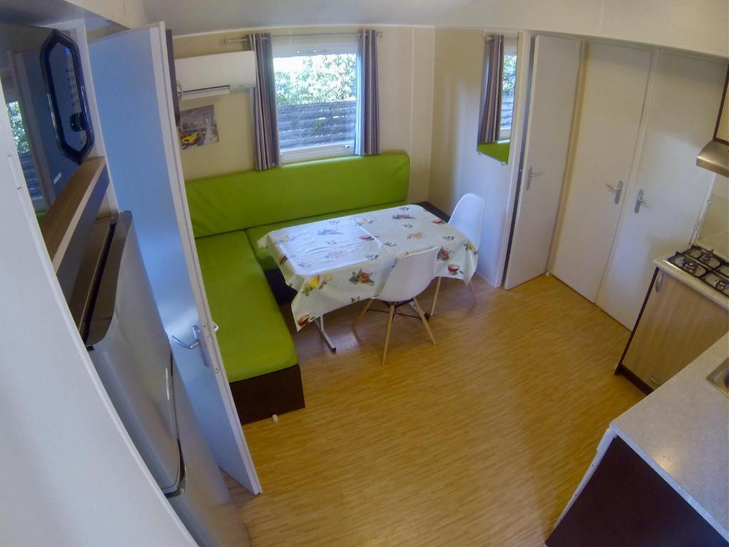 Cette petite chambre comprend une table et un canapé vert. dans l'établissement Les Salins de la Gardiole, à Vic-la-Gardiole