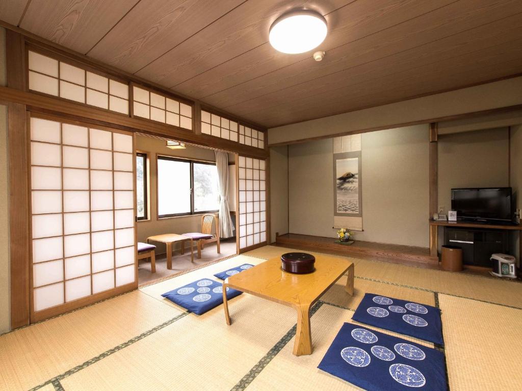 un salon avec une table et des tapis bleus dans l'établissement Sagirisou, à Nagano