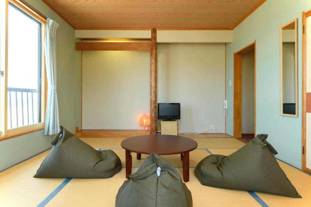 un salon avec une table et deux chaises dans l'établissement Tabist Odakeya Ryokan Kashiwazaki, à Kashiwazaki 37 autres photos