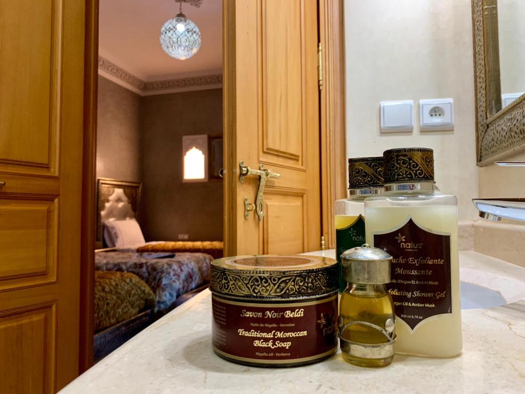 - une salle de bains avec 2 bouteilles d'huiles essentielles sur un comptoir dans l'établissement Riad Miral, à Marrakech
