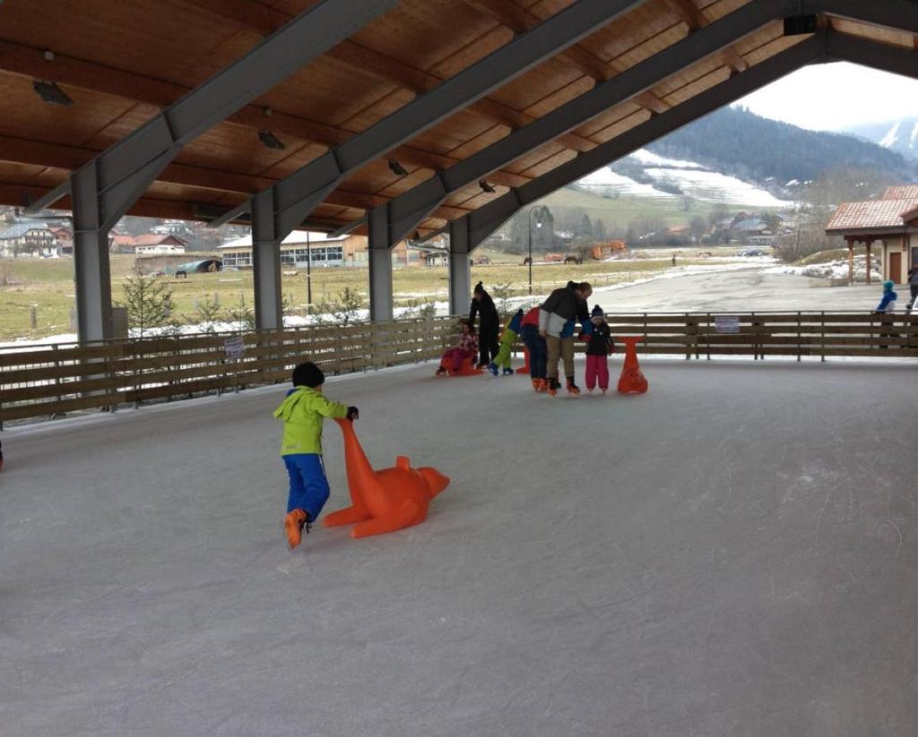 un groupe d'enfants jouant avec des cônes orange dans la neige dans l'établissement Le 211,ski et randonnée, lave linge , parking gratuit, à Bernex