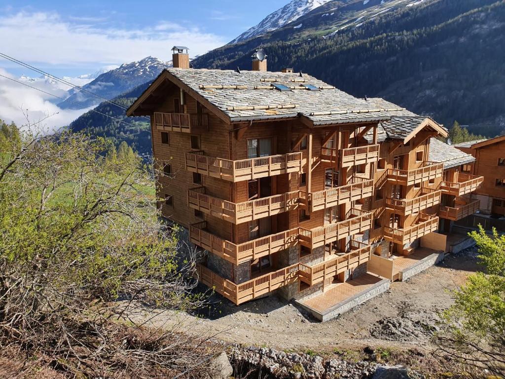 un grand bâtiment en bois au sommet d'une montagne dans l'établissement Appartement Soleil Blanc Résidence Lodge des neiges, à Tignes
