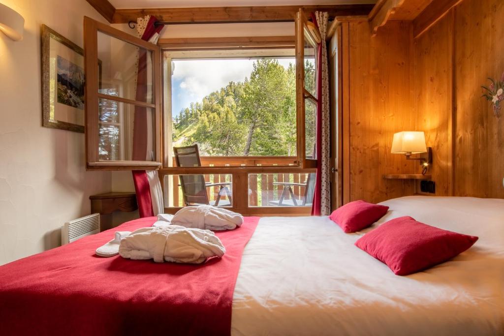 - une chambre avec un lit doté de draps rouges et une fenêtre dans l'établissement L'Ekrin des Arcs - Arc 1950 Le Village - Duplex 6-8 pers, à Arc 1950