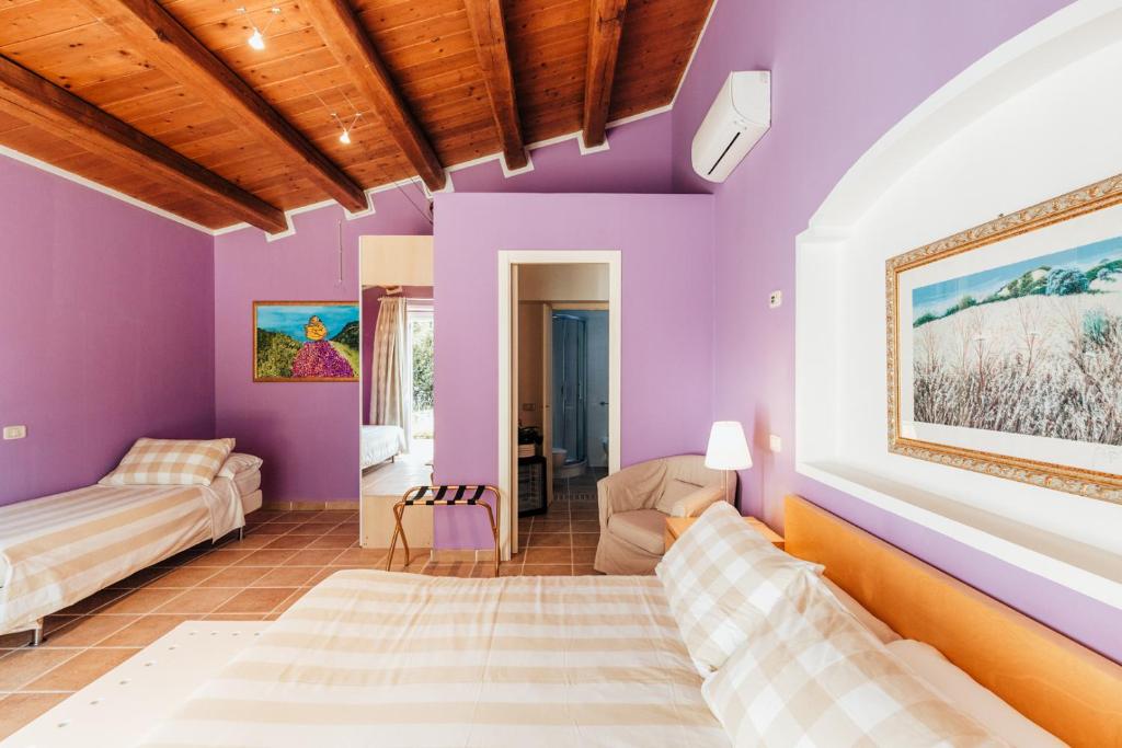 - un salon avec des murs violets et un canapé dans l'établissement Alle Pendici del Conero, à Sirolo