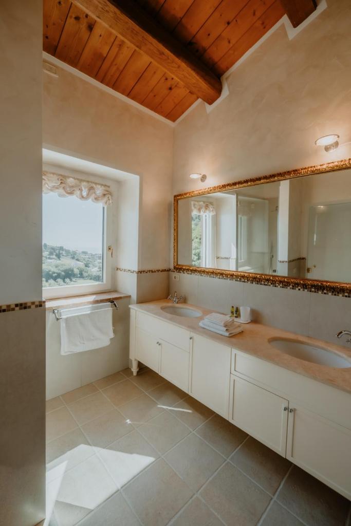 une salle de bain avec deux lavabos et un grand miroir dans l'établissement Alle Pendici del Conero, à Sirolo 51 autres photos