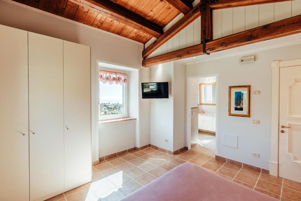 Cette grande chambre présente des murs blancs et un plafond en bois. dans l'établissement Alle Pendici del Conero, à Sirolo