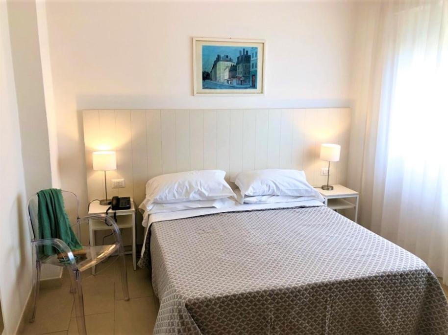 - une chambre avec un lit, deux tables et deux lampes dans l'établissement Hotel Villa Eleonora, à Scauri