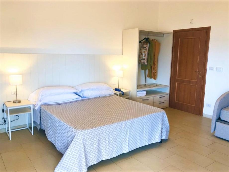 une chambre avec un lit, une table et un miroir dans l'établissement Hotel Villa Eleonora, à Scauri
