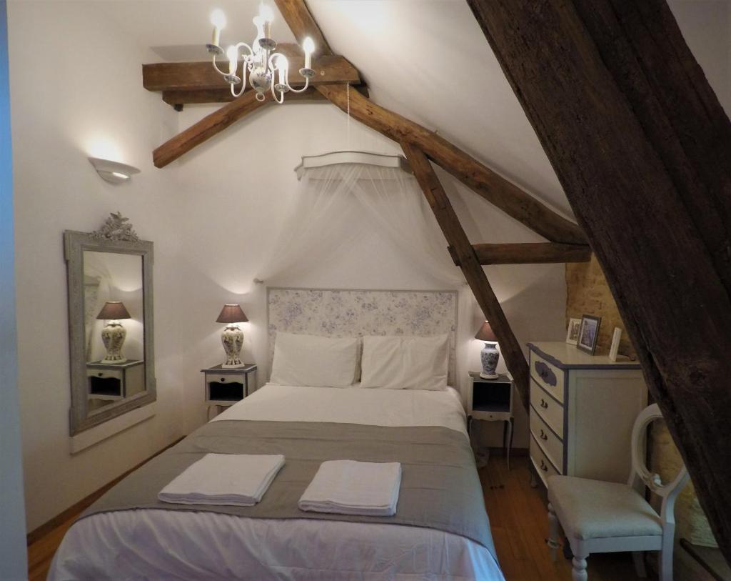 une chambre avec un lit et un lustre dans l'établissement La Libellule and Le Papillon gites at Les Leroux, near Frayssinet-le-Gelat, à Frayssinet-le-Gélat