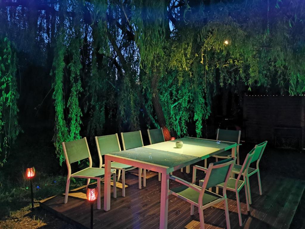 - une table et des chaises dans le jardin la nuit dans l'établissement Mas de Férigoulet -"La Rose des Vents"& Univers enfants "Lou Pitchoun", à Orgon