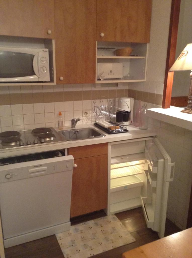 une cuisine avec un évier et une cuisinière four supérieur dans l'établissement Résidence Les Mélèzes, à L'Alpe-d'Huez