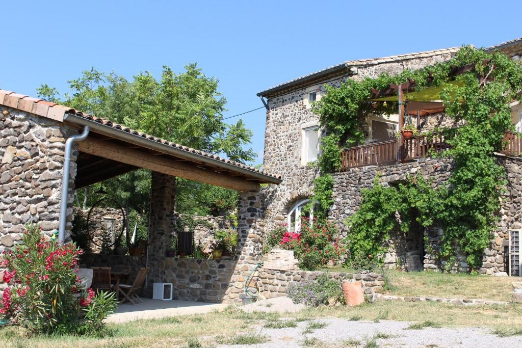 Elle offre une vue sur l'extérieur d'une maison en pierre dotée d'un balcon. dans l'établissement L'Attrape Rêve Insolite, à Saint-Vincent-de-Barrès