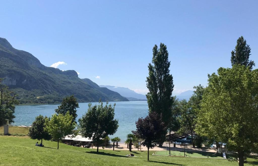 Elle offre une vue sur un lac avec des arbres et des montagnes. dans l'établissement Eco Yourte Lac du Bourget, à Conjux 28 autres photos