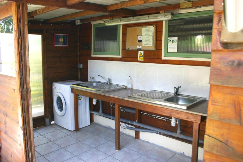 une cuisine avec deux lavabos et un lave-linge dans l'établissement Safari at La Petite Lande, à Pierrefiche