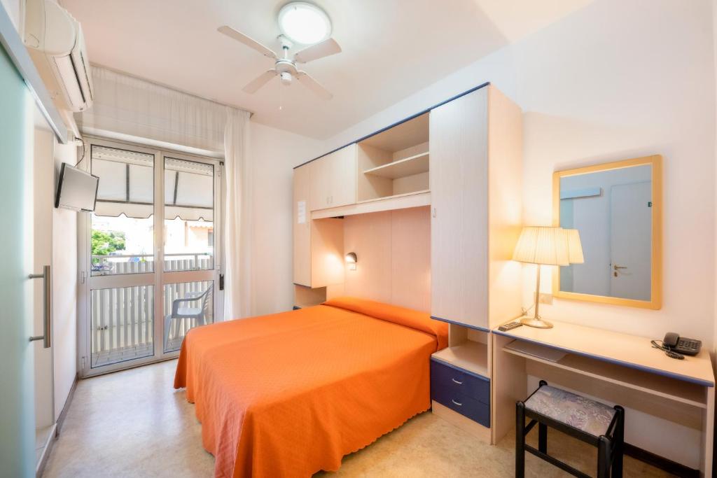 une chambre avec un lit, un bureau et une fenêtre dans l'établissement Hotel Firenze, à Caorle