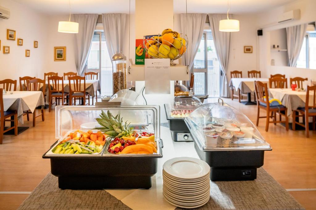 - un buffet de fruits et légumes sur un comptoir dans un restaurant dans l'établissement Hotel Firenze, à Caorle