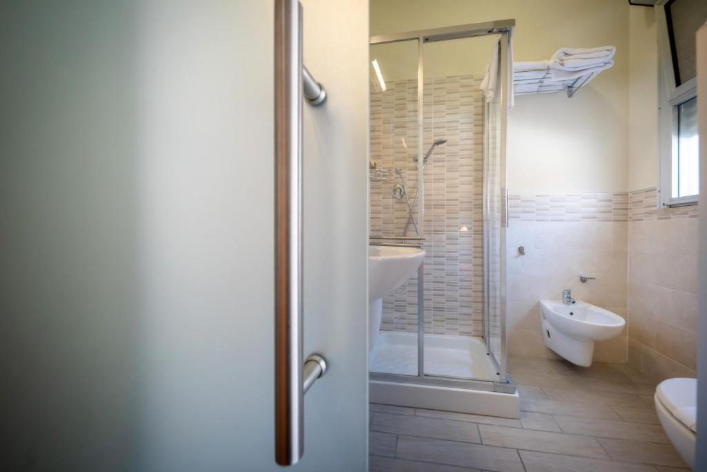 une salle de bain avec une douche, des toilettes et un lavabo dans l'établissement Hotel Firenze, à Caorle