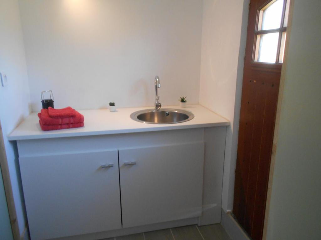 une salle de bain avec un lavabo et une serviette rouge dans l'établissement 2 Yourtes au naturel, à Druyes-les-Belles-Fontaines