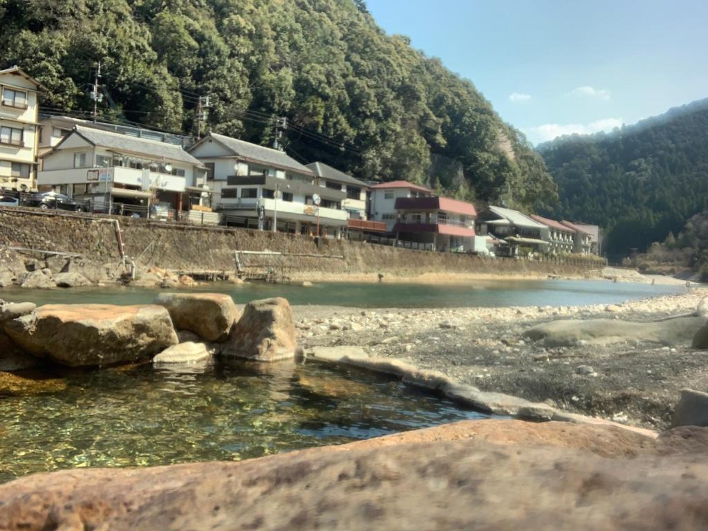 un groupe de maisons au bord d'une rivière dans l'établissement Minshuku Sumiya, à Tanabe