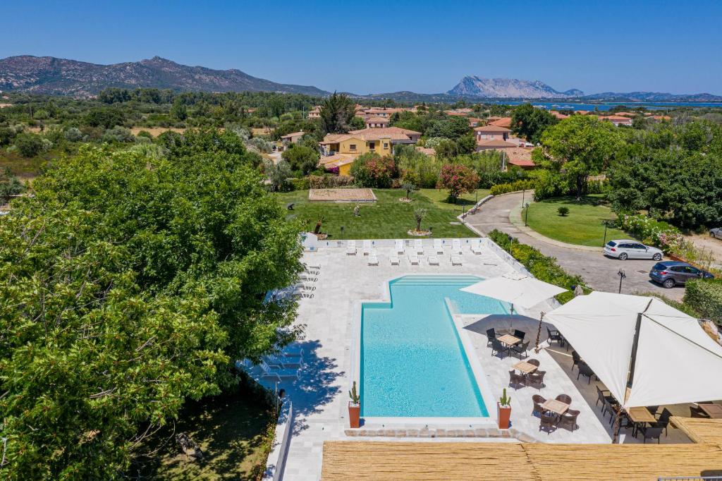 une vue aérienne d'une piscine avec parasols et chaises dans l'établissement Hotel Le Mimose, à San Teodoro