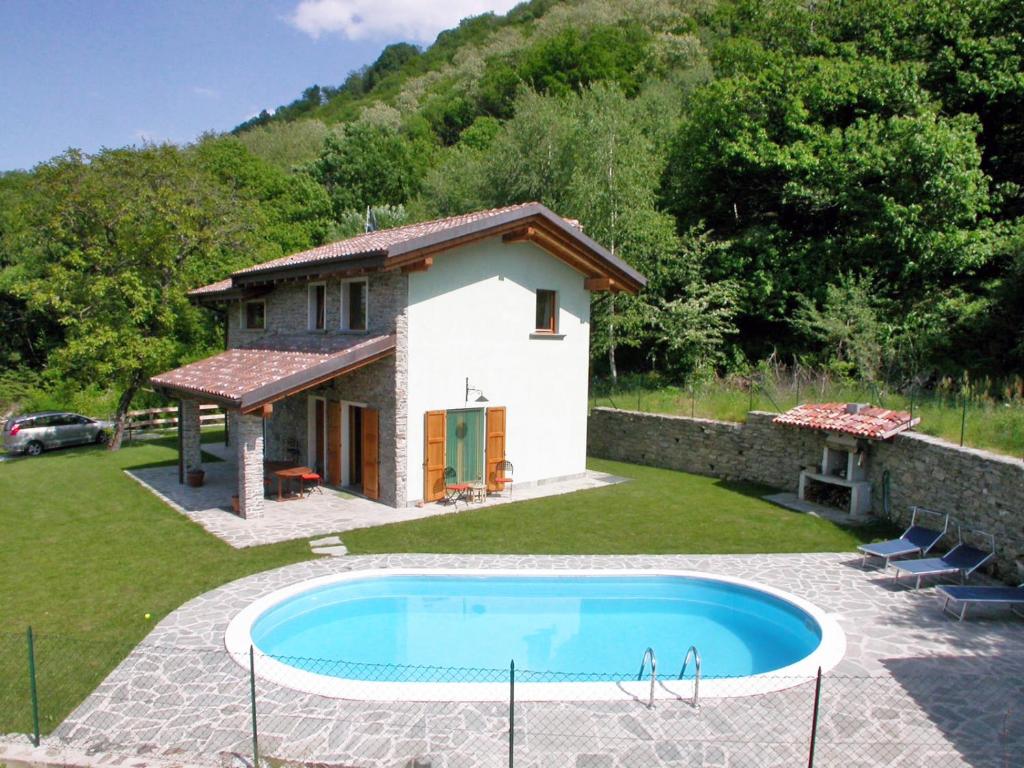 une maison avec une piscine devant dans l'établissement Villa Betulla con piscina privata sul lago di Como, à Colico