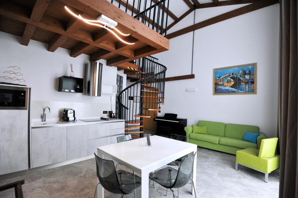 un salon avec une table blanche et un canapé vert dans l'établissement Hotel Marzia Holiday Queen, à Caorle