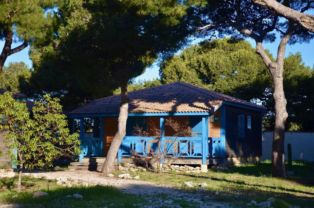 un hangar bleu avec toit sur une cour dans l'établissement Martigues, les Chalets de la Mer ****, à Martigues
