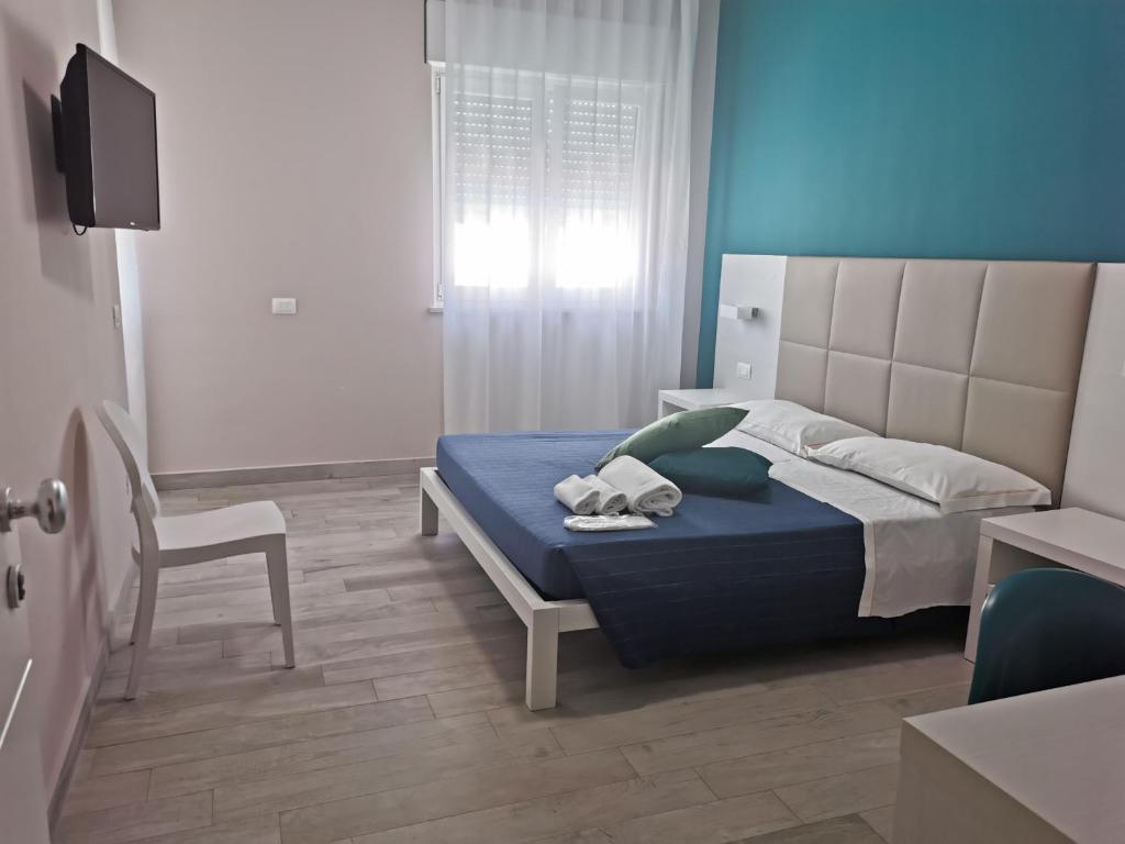 une chambre avec un lit et une chaise dedans dans l'établissement Elite Boutique Hotel, à Roseto degli Abruzzi