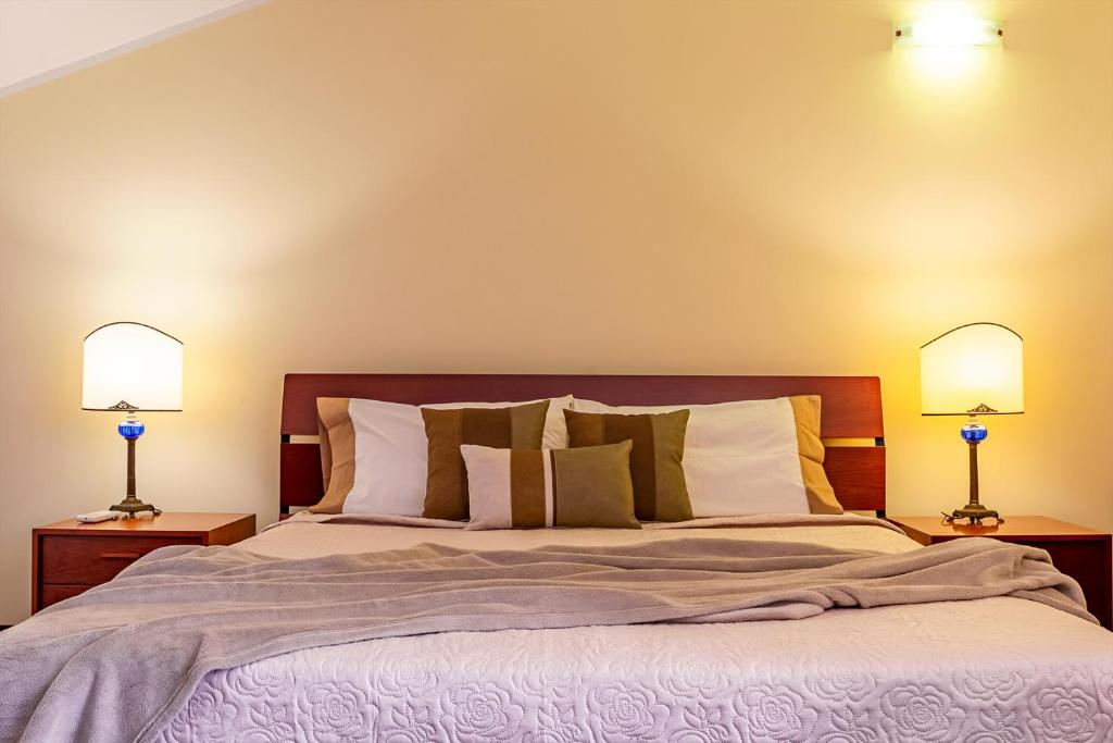 une chambre avec un grand lit avec deux lampes dans l'établissement Villa Magdalena, à Aci SantʼAntonio 21 autres photos