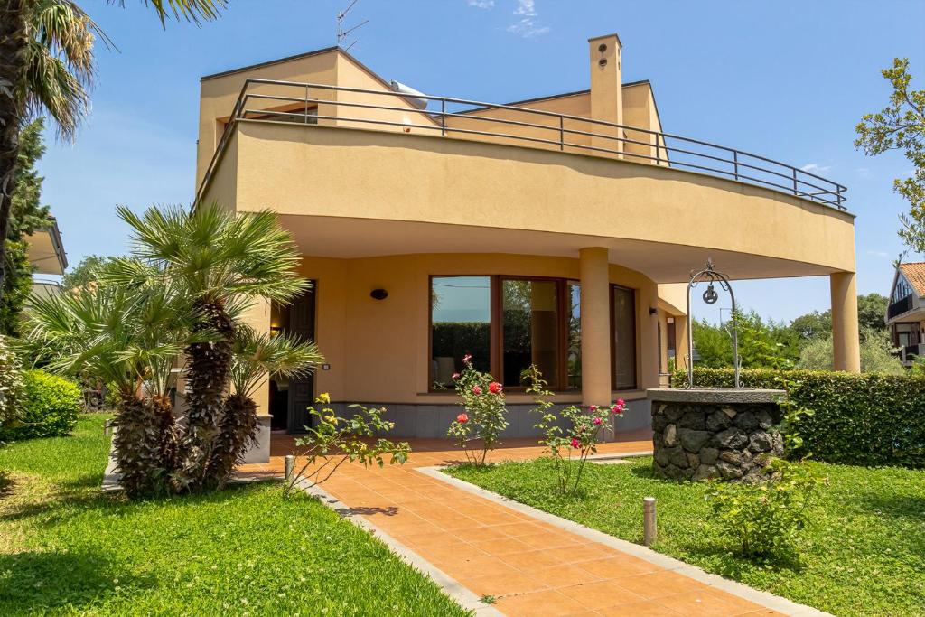 une maison avec un balcon au-dessus dans l'établissement Villa Magdalena, à Aci SantʼAntonio