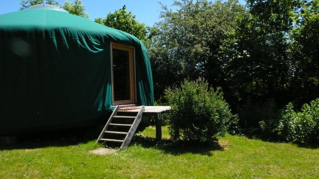 une tente verte avec une échelle dans l'herbe dans l'établissement La Yourte, à Moussages 12 autres photos