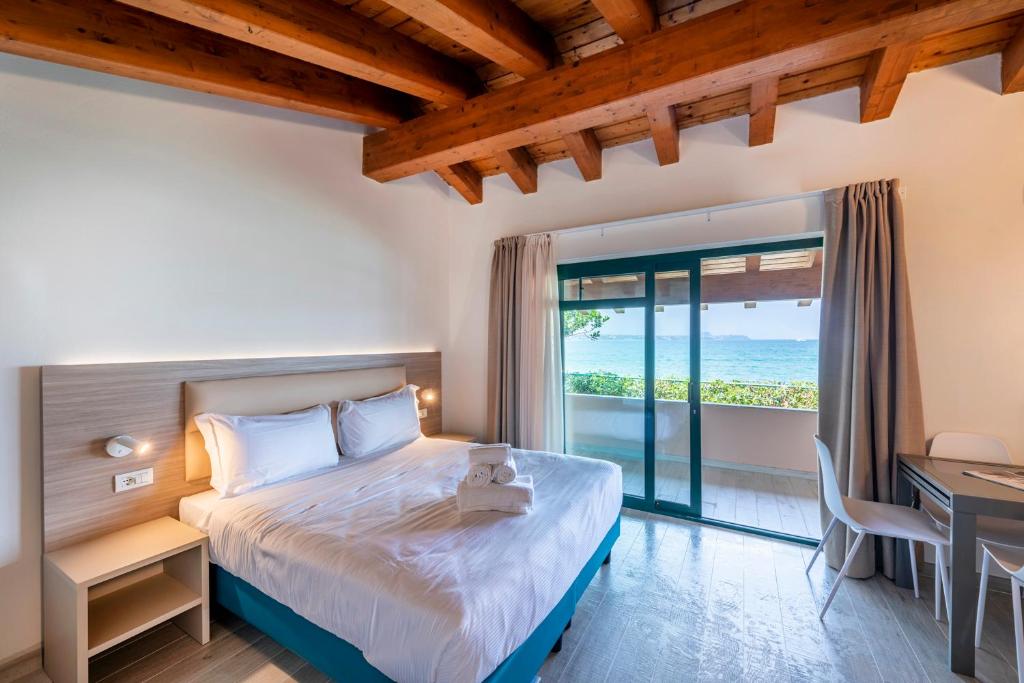 une chambre avec un lit, un bureau et une fenêtre dans l'établissement Club del Sole Desenzano Boutique Resort, à Desenzano del Garda