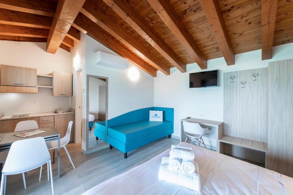 un salon avec un canapé bleu et une table dans l'établissement Club del Sole Desenzano Boutique Resort, à Desenzano del Garda