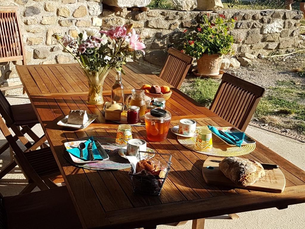 - une table en bois avec de la nourriture et des fleurs dans l'établissement L'Attrape Rêve Insolite, à Saint-Vincent-de-Barrès