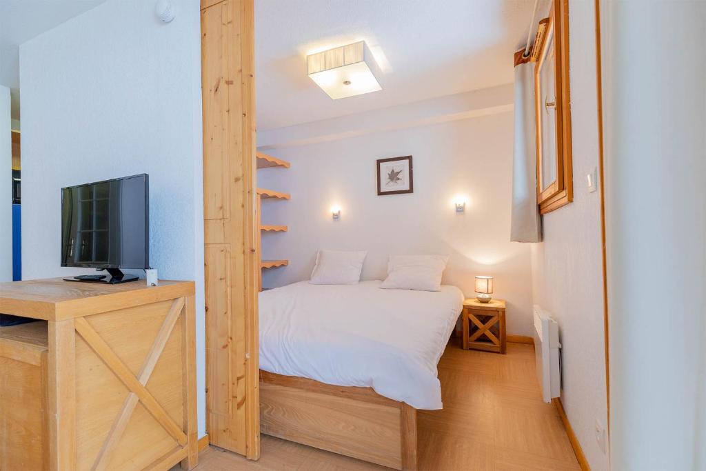 une petite chambre avec un lit et une télévision dans l'établissement Madame Vacances Résidence Le Parc Des Airelles, aux Orres
