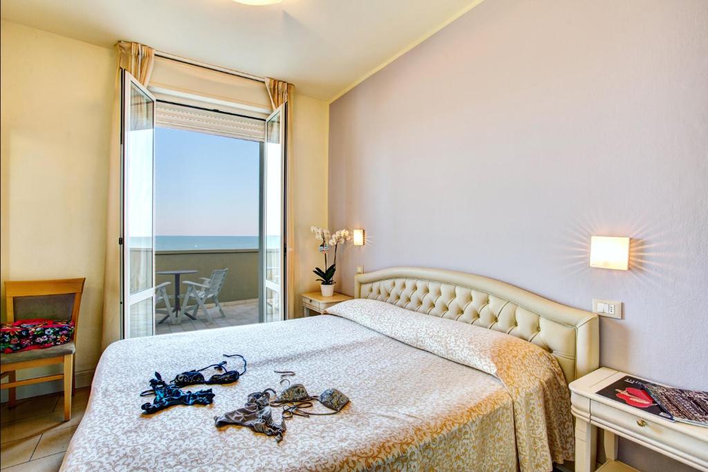 une chambre avec un lit avec des chaussures dessus dans l'établissement Brasil Seaview Hotel, à Milano Marittima