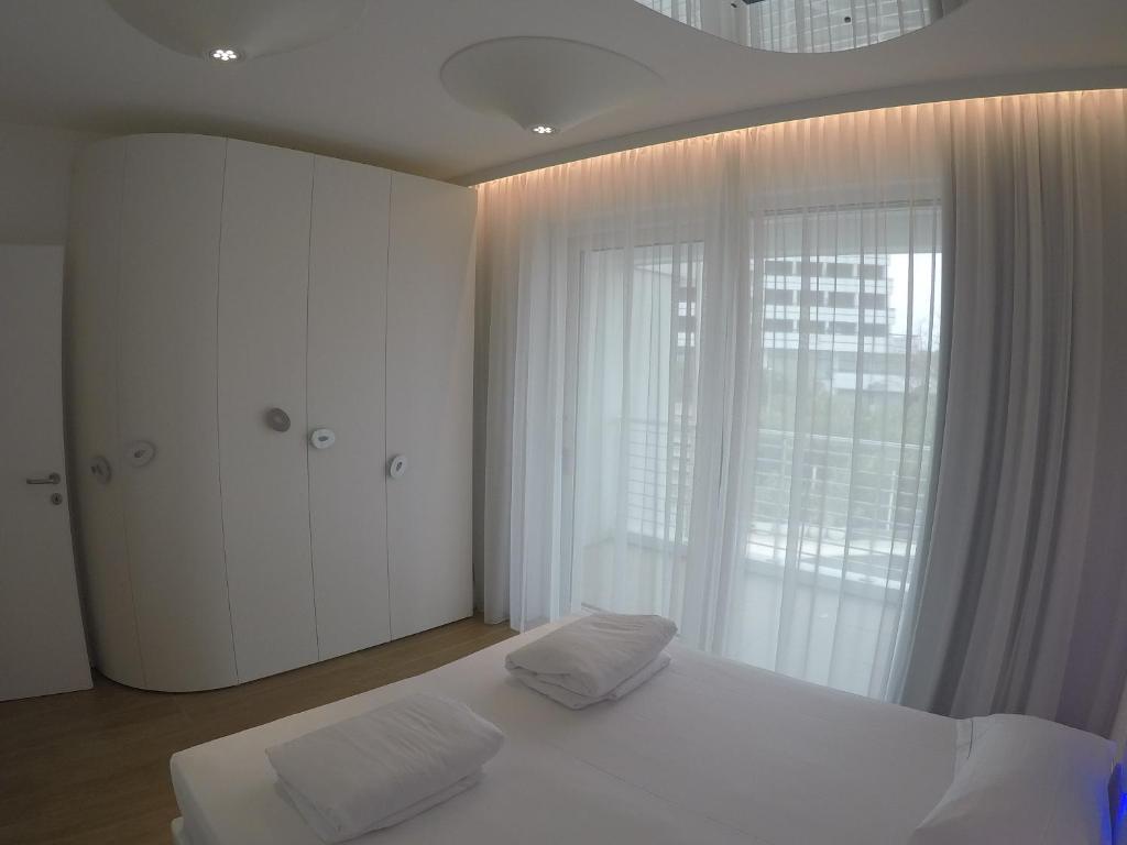 une chambre avec un lit blanc et une grande fenêtre dans l'établissement Marina Verde Resort Official, à Caorle 59 autres photos