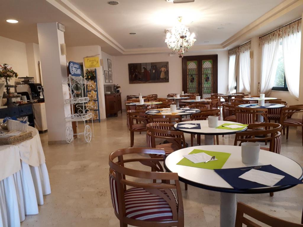 un restaurant avec des tables et des chaises dans une salle dans l'établissement Hotel Fiorella, à Senigallia