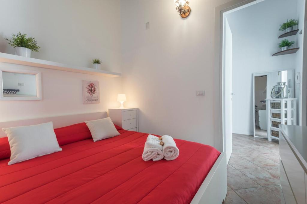 une chambre avec un lit rouge avec des serviettes dessus dans l'établissement Koreble In Disco, à Marina di Ragusa