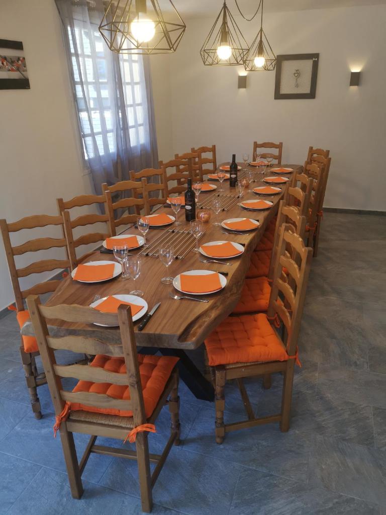 une grande table en bois avec des panneaux orange et des verres dans l'établissement Grand Chalet St-Lary centre 13 à 15 pers, à Saint-Lary-Soulan
