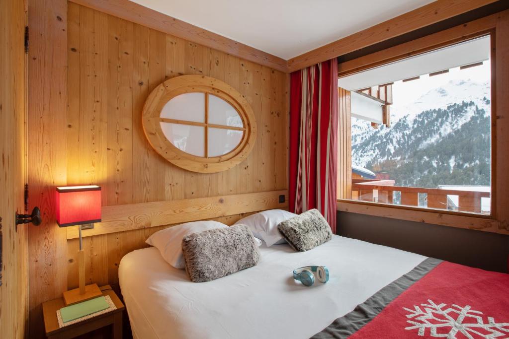 - une chambre avec un lit et une fenêtre donnant sur la montagne dans l'établissement Résidence Pierre & Vacances Premium les Crets, à Les Allues