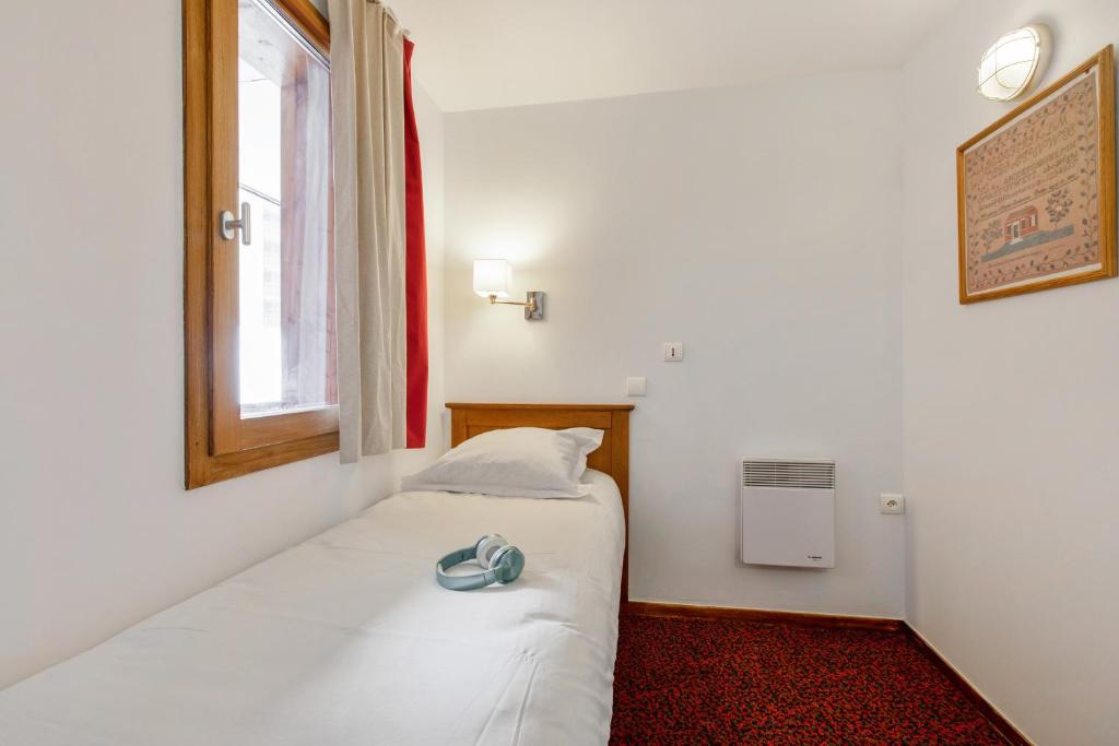 une petite pièce avec un lit et une fenêtre dans l'établissement Résidence Pierre & Vacances Le Mont Soleil, à La Plagne
