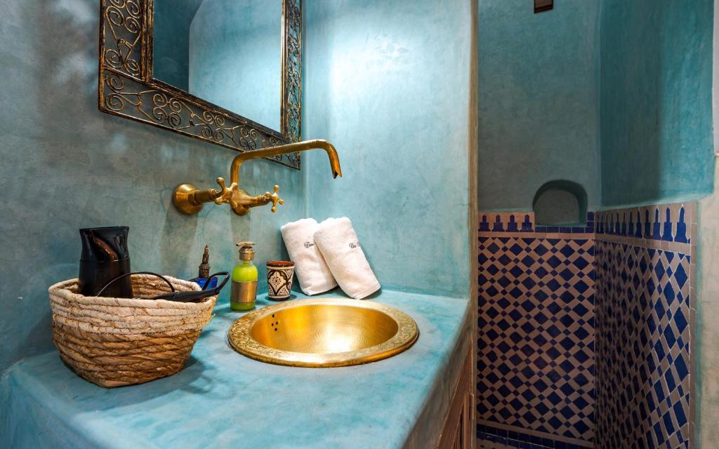 La salle de bains est pourvue d'un lavabo en or et d'un miroir. dans l'établissement Dar Picolina, à Marrakech
