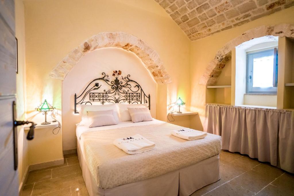une chambre avec un grand lit dans une pièce dans l'établissement Trulli Ad Maiora, à Alberobello
