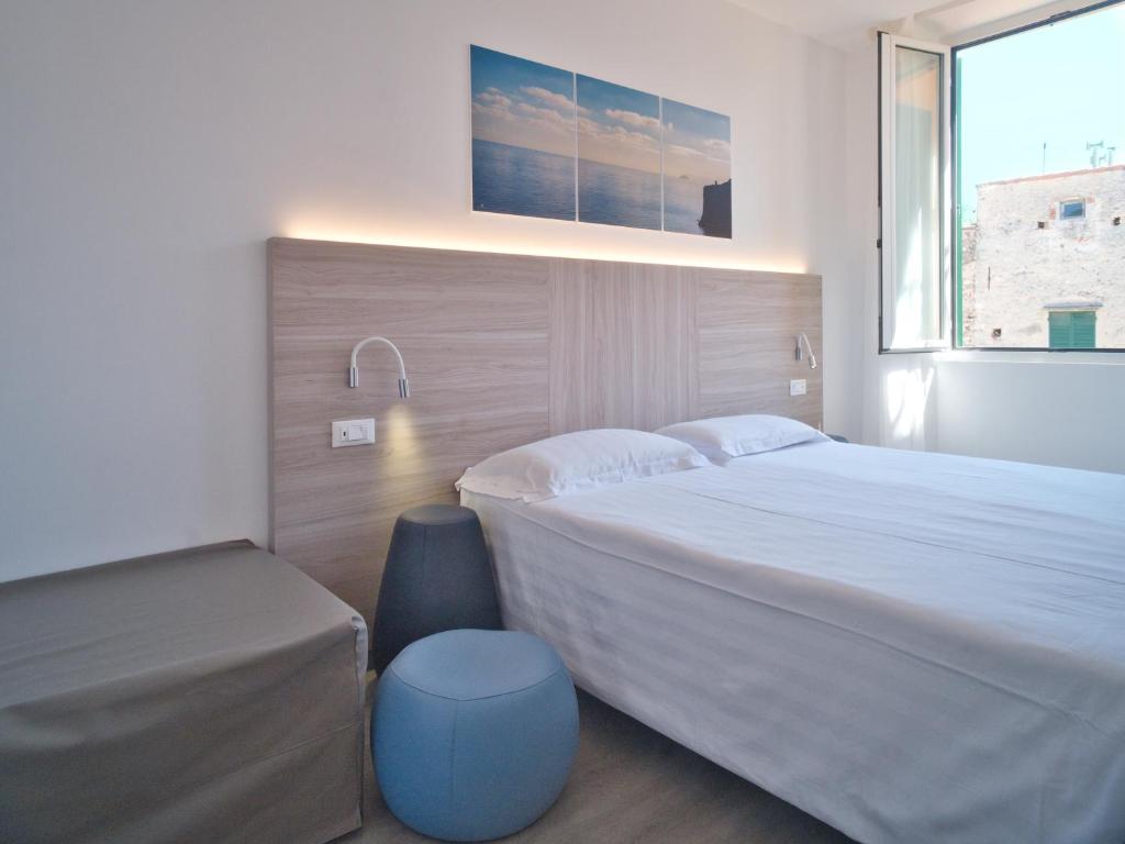 une chambre avec un grand lit et une fenêtre dans l'établissement Hotel Medusa, à Finale Ligure